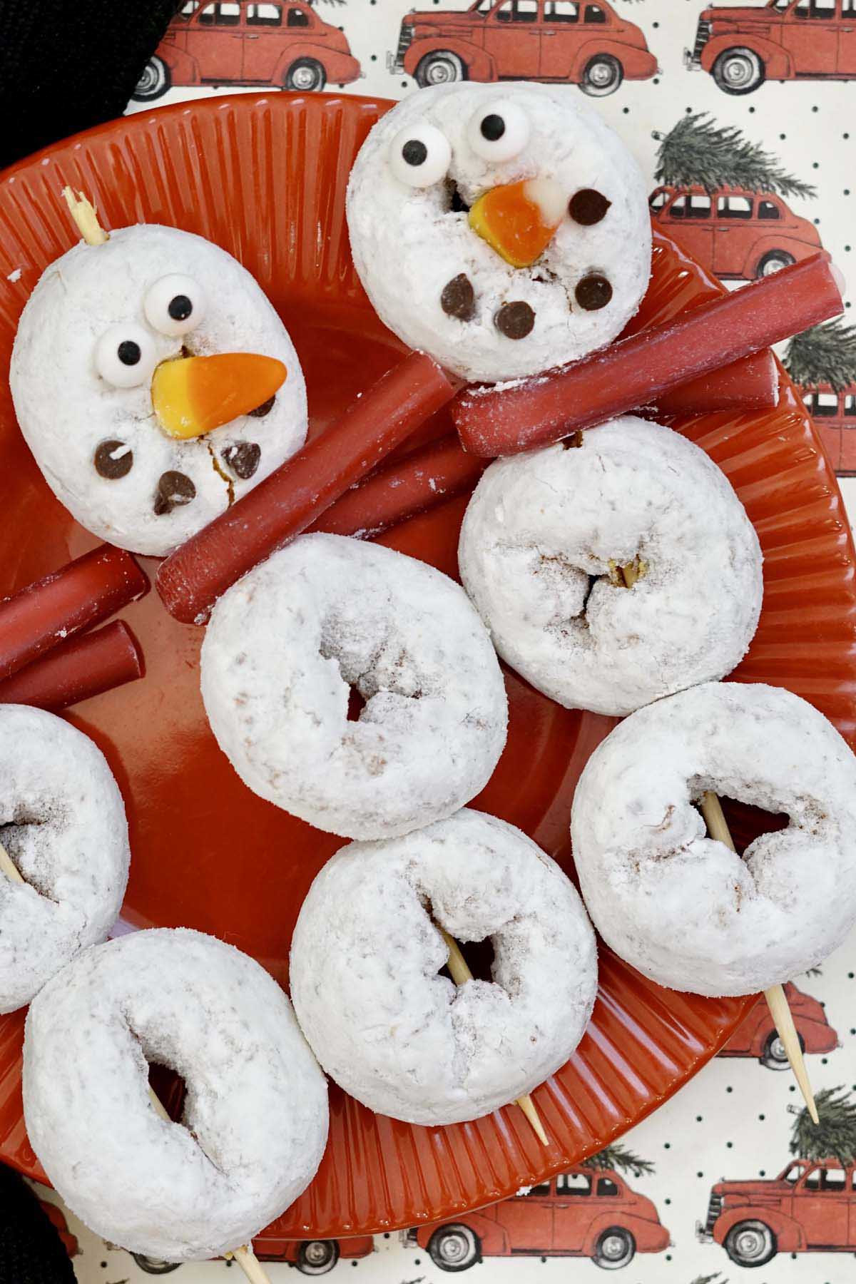 close up view of two snowman donut on a plate.