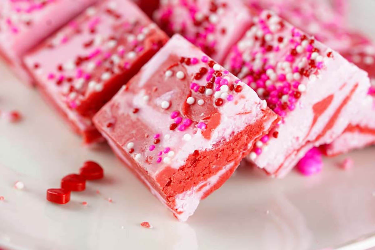 red and pink fudge cut into bars.