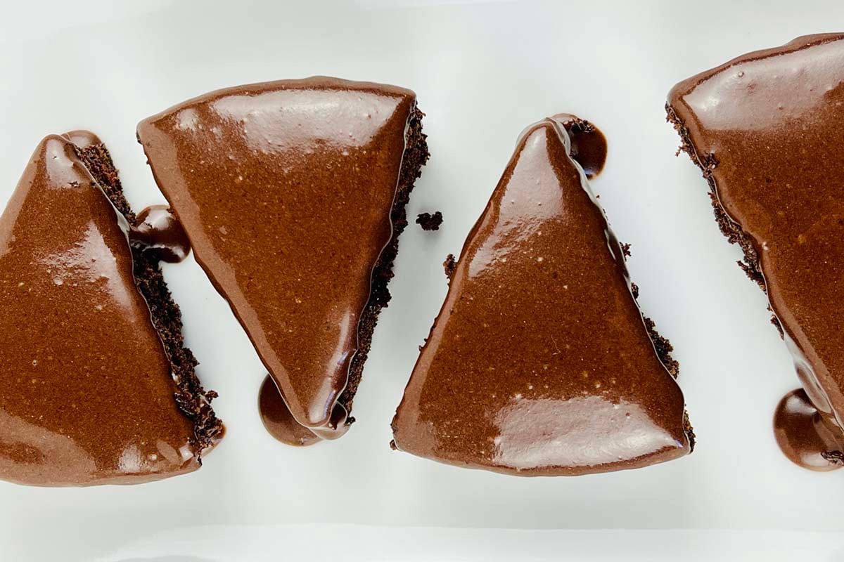 four slices of chocolate cake on a plate.