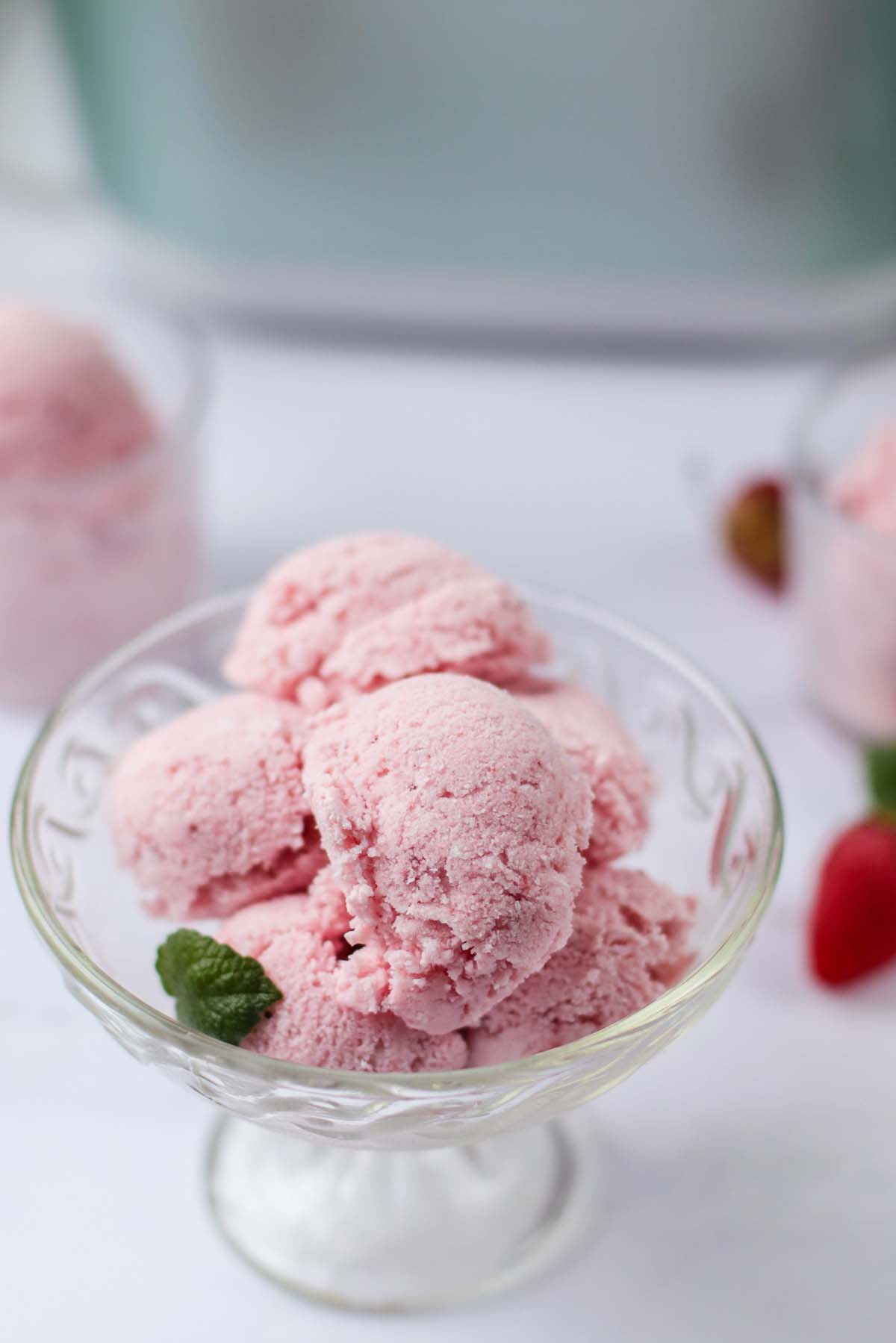 strawberry ice cream scooped in a glass dish.