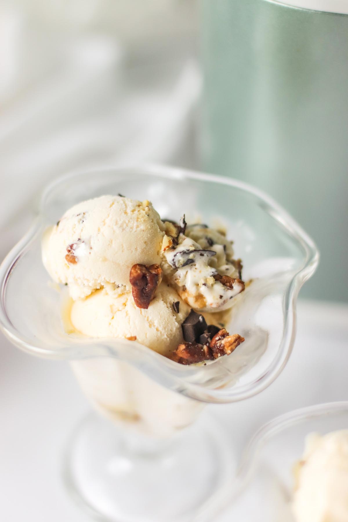 ice cream topped with pecans in a glass dish.