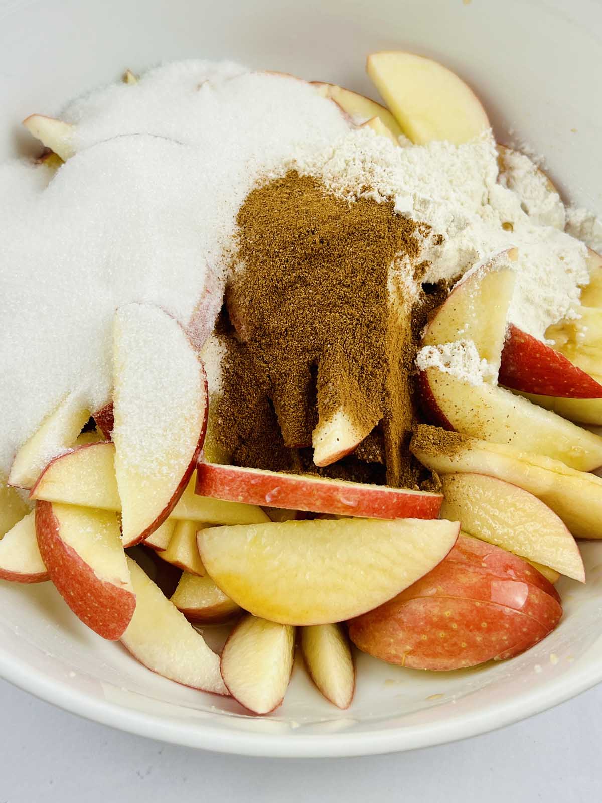 Apples in a bowl topped with filling ingredients.