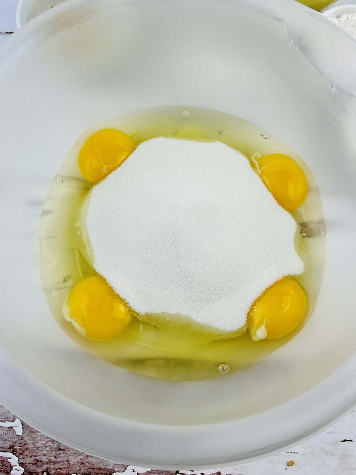 Eggs and sugar in a mixing bowl.