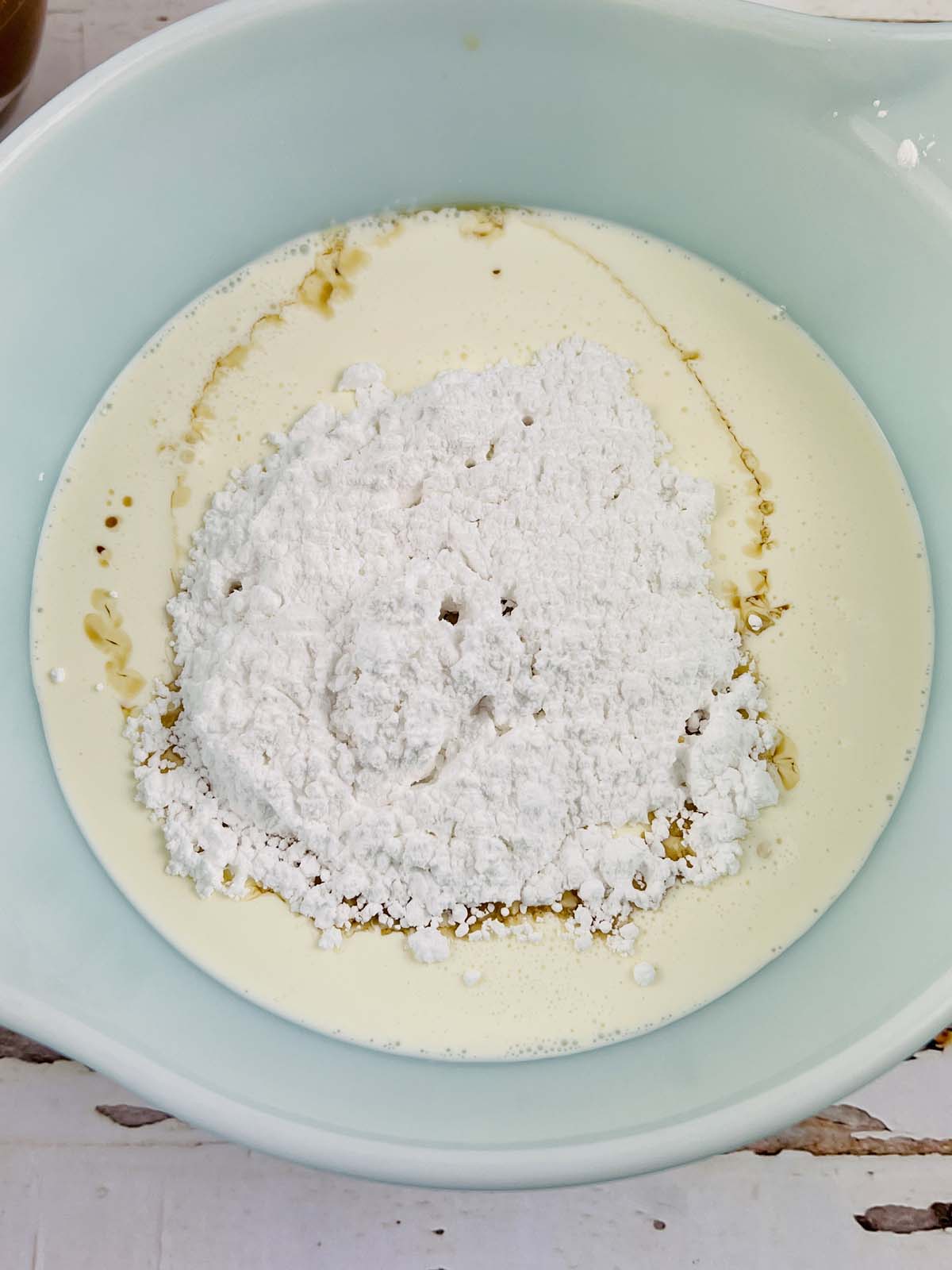Powdered sugar in a bowl with the mixed wet ingredients.