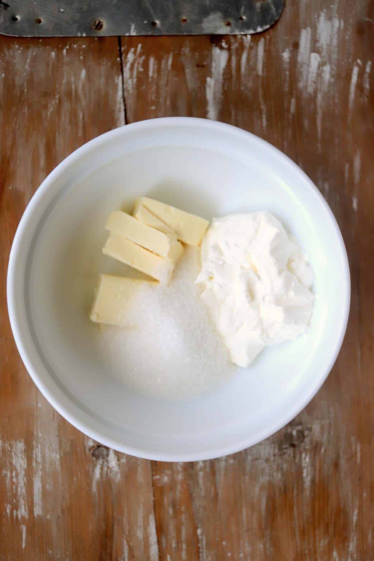 Butter, sugar and cream cheese in a mixing bowl.