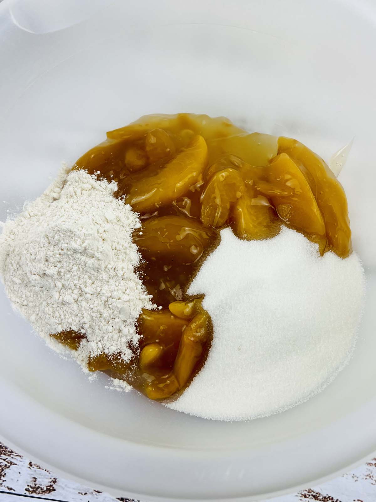 Peach filling, flour and sugar in a mixing bowl.