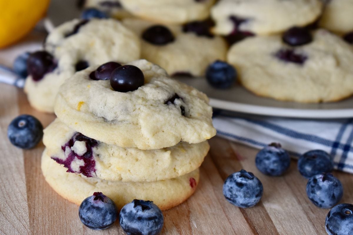 Lemon Blueberry Cookies on a cutting board with blueberries. 