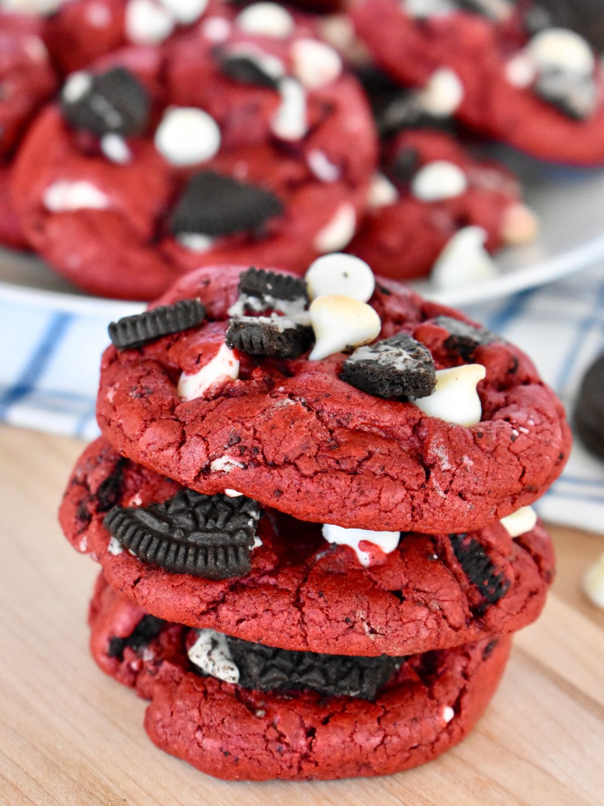 Red Velvet Oreo Cookies with white chocolate chips stacked on a countertop. 