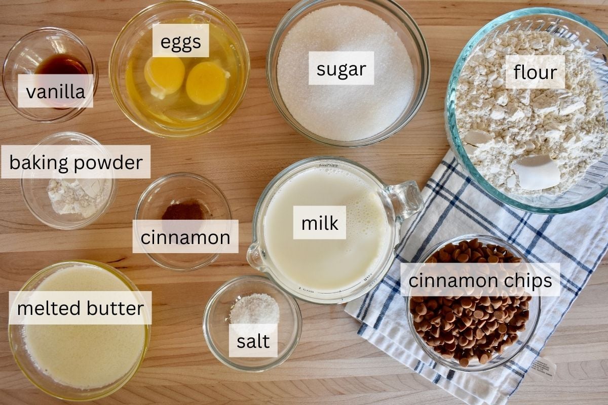 Ingredients on a countertop including flour, sugar, eggs, and melted butter. 