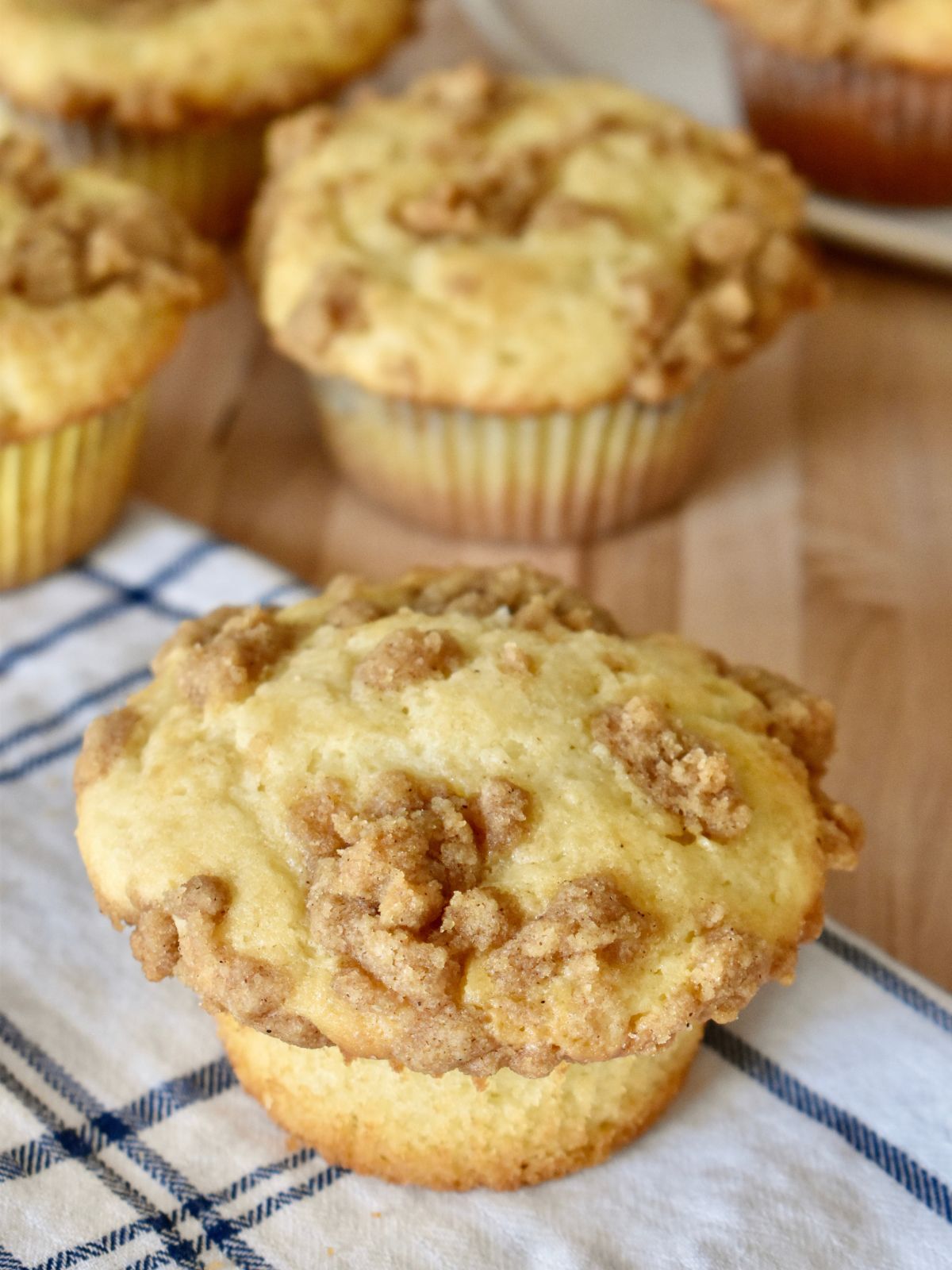 Cinnamon Streusel Muffins with more muffins stacked in the background. 