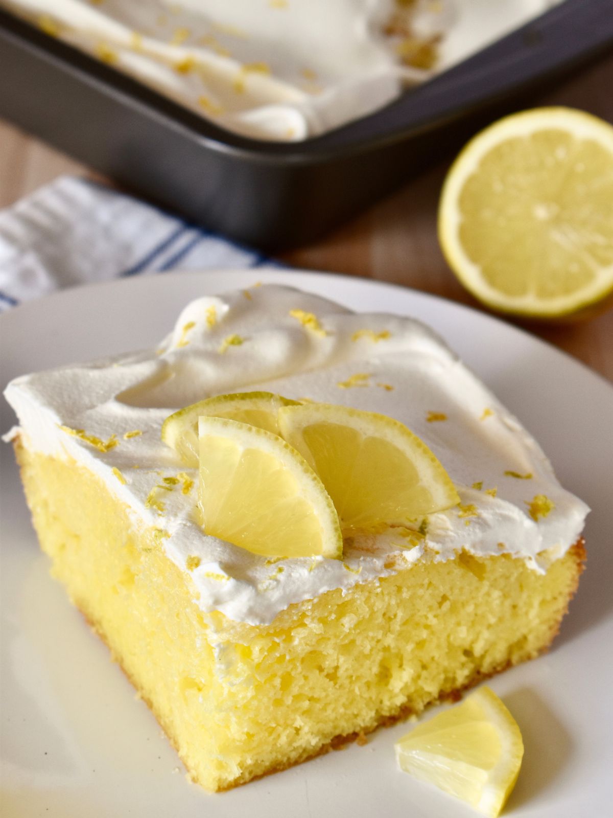 Lemon Poke Cake on a white plate. 