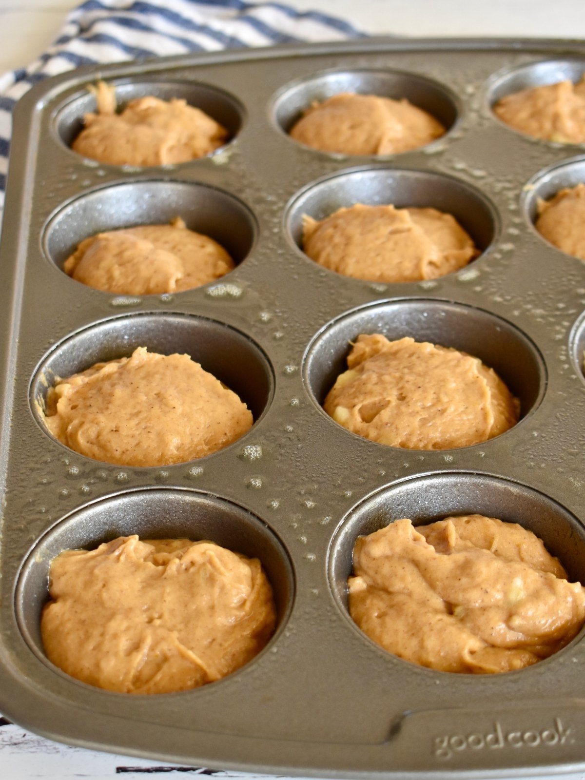 Muffin tin filled with pumpkin banana muffins batter.